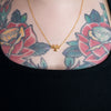18k gold plated necklace with bio-heart-zard symbol on tattooed model
