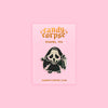 Enamel pin of a kawaii horror movie icon. Sitting on a pink backing card with gold foil Candy Corpse logo.