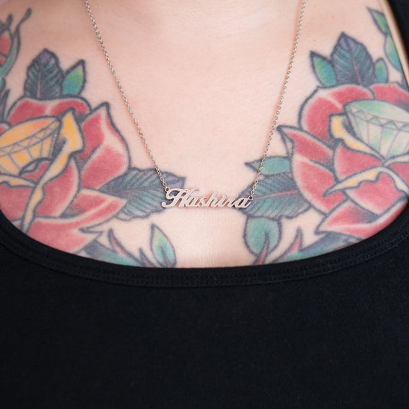 Silver necklace that says "Hashira" on tattooed model