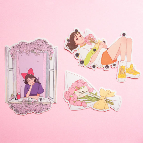 Three stickers next to each other: one of a girl looking out a window, one of a girl laying down with a bouquet, and one of a bouquet of flowers with a goodbye card.