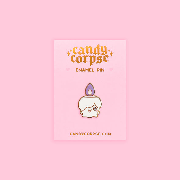 Enamel pin of cute candle monster on pink backing card with gold foil embossed Candy Corpse logo