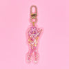 Acrylic keychain with star holographic finish and gold key ring. Artwork shows an adorable nurse with pink hair holding an oversized syringe with hearts.