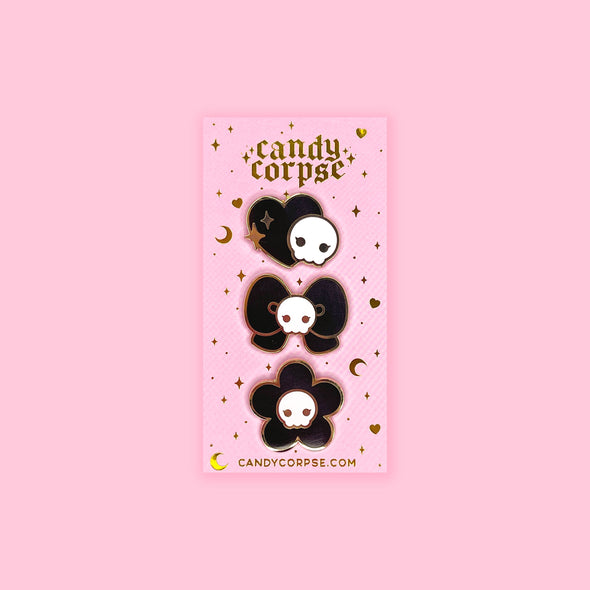Creepy cute skull themed enamel pin set on pink and gold foil backing card